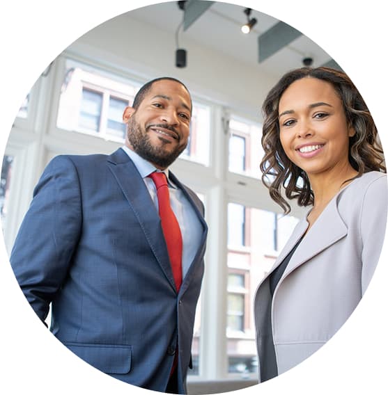 Two colleagues, a man and a woman, smiling together in a bright office